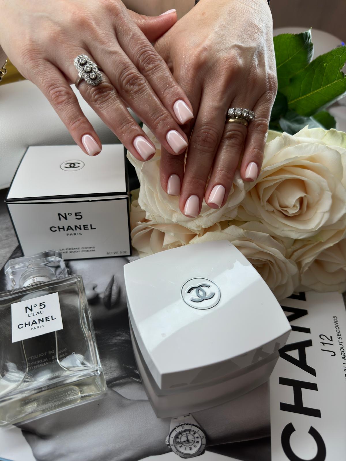 Korte, zachtroze square nagels met twee handen over elkaar